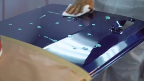 Worker is putting polishing material on the surface of a sample car door. Stock Footage 138276469
