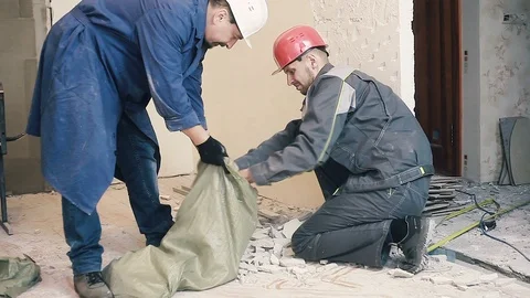 A worker is putting soil debris in a bag Stock Footage 99793178