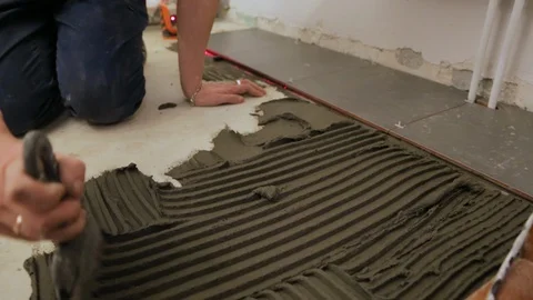 Worker putting tile glue on floor Stock Footage 128415496