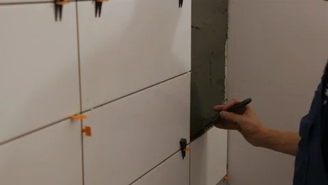 Worker putting tile glue on wall Видео 128413711