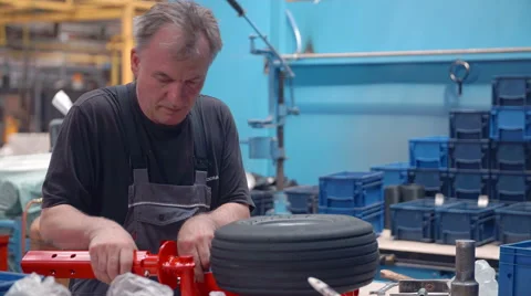Worker is putting together a few items in a plant in order to finish a product Stock Footage 58884527