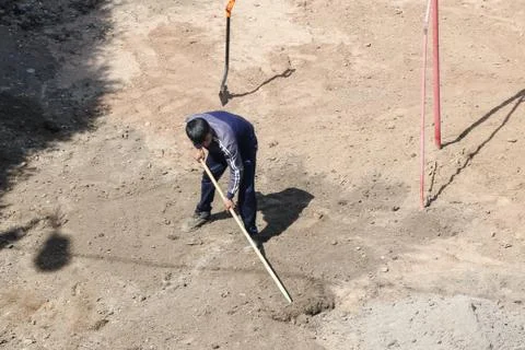 Worker with a rake on the layout. Photos