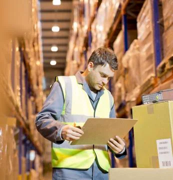 Worker reading clipboard in warehouse Stock Photos