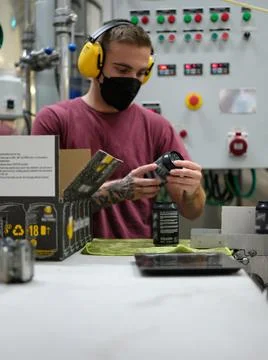 Worker reading the label on a beer can before packing it for shipment Stock Photos