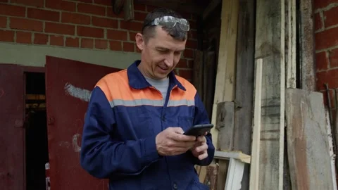 Worker reads a message on the phone Stock Footage 195860143