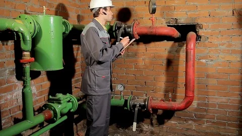 The worker records the readings of the manometer on the clipboard. The engineer Stock Footage 76259594