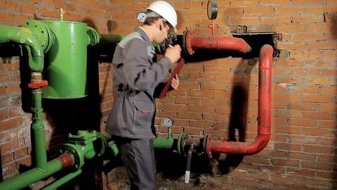 The worker records the readings of the manometer on the clipboard. The engineer 動画素材 76259745