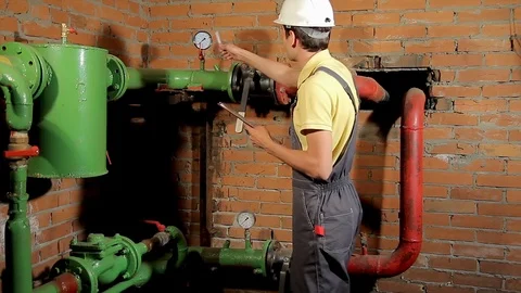 The worker records the readings of the manometer on the clipboard. The engineer Stock Footage 77121136