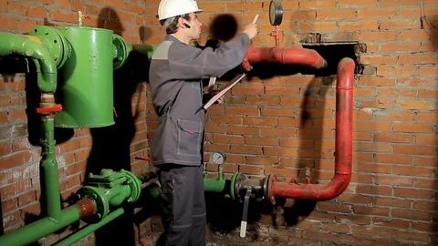 The worker records the readings of the manometer on the clipboard. The engineer Stock-Footage 77123092