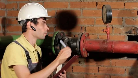 The worker records the readings of the manometer on the clipboard. take meter Stock Footage 77125676