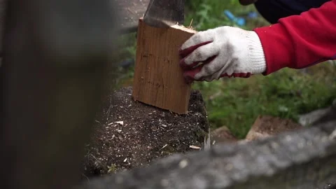 A worker in red clothes and safe red and white gloves cuts the board in half Stock Footage 131406984