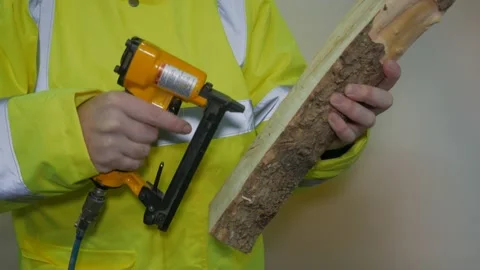 A Worker in A Reflective Uniform Clogs With A Stapler Stock-Footage 220016758