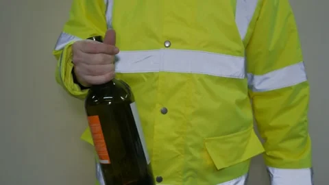 Worker in reflective uniform drunk with a bottle Stock-Footage 220433412