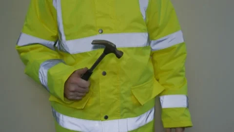 Worker in reflective uniform holding a hammer Stock Footage 220433382