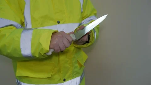 A worker in a reflective uniform sharpens a pencil Stock-Footage 220433364