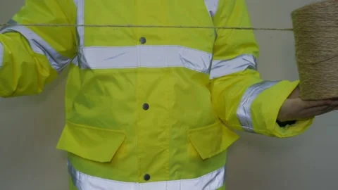 A worker in reflective uniform unwinds a rope Stock-Footage 220433571