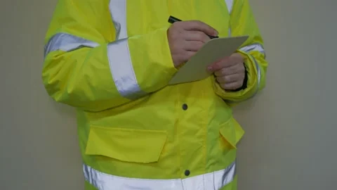 Worker in reflective uniform writing on paper Stock Footage 220433339