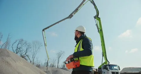 A worker with a remote control in his hands controls a pump for concrete Stock Footage 277595662