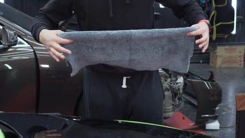 Worker removes all dirt from machine body before applying next coat of polish Stock Footage 115933877