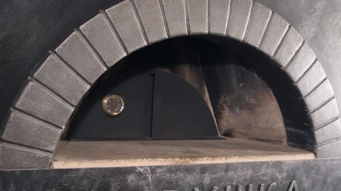 Worker removes door and opens oven to fill with firewood Stock Footage 126950995