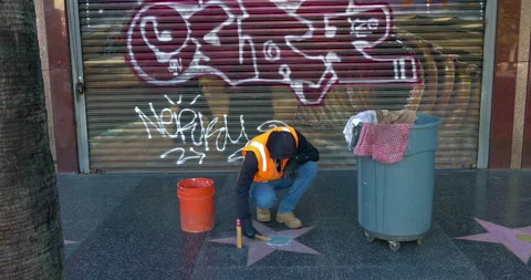 Worker removes graffiti from star and wall on Walk of Fame in Hollywood, LA, 4K Video stock 144558558