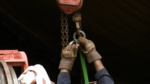 Worker removing large heavy chain strap from crane Stock Footage 123728872