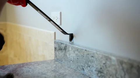 Worker removing old kitchen or bathroom furniture during home renovation using Stock Footage 330987071
