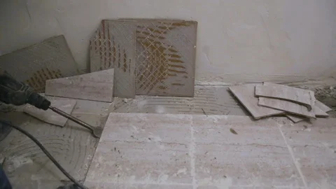 Worker removing old tile from the floor in bathroom Stock Footage 128409787