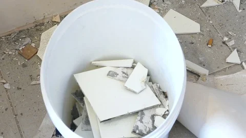 Worker removing old tiles and throwing it in a can Stock Footage 71370037