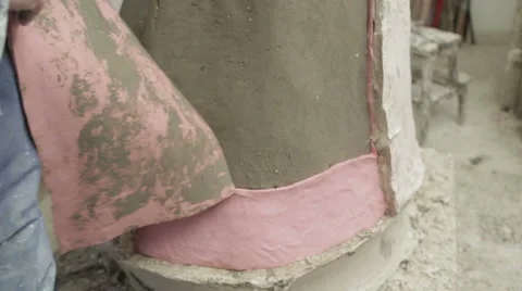 A worker removing silicon from a clay model to be later cast in bronze Stock Footage 58639079