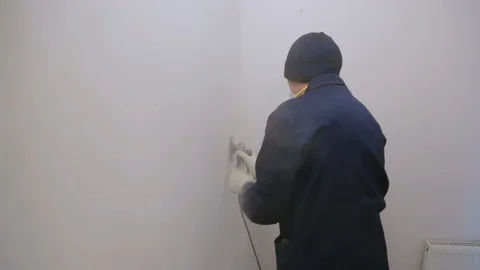 Worker removing surface cover from the wall 库存影片 128409192
