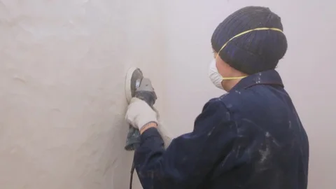 Worker removing surface cover from the wall Stock Footage 128409721