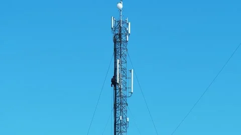 Worker repair a cell tower. High-altitude work. Workman at the work Stock Footage 313876707