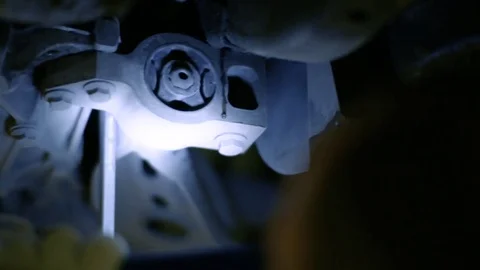 The worker is repairing the car. The key is screwed in the bottom of the car Stock Footage 80468797