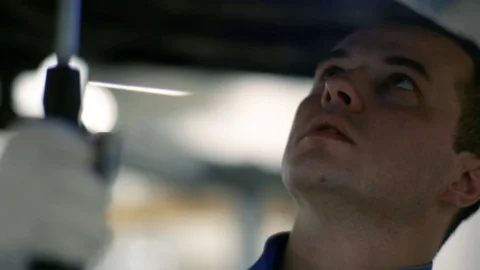 The worker is repairing the car. The key is screwed in the bottom of the car Stock Footage 80469920