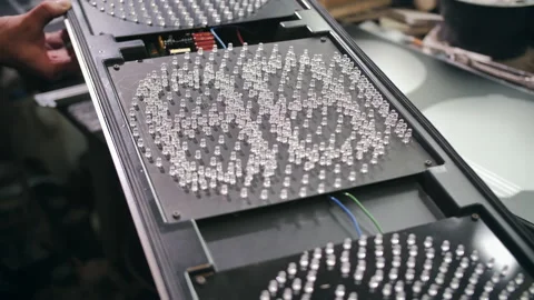 A worker repairs, tests a new traffic light at a factory. LEDs, energy saving Stock-Footage 137649260