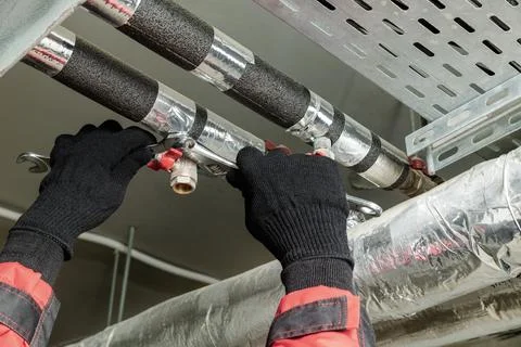 Worker repairs the water supply system. Stock Photos