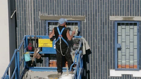 Worker restores the facade of the building with elevator Stock Footage 49576856