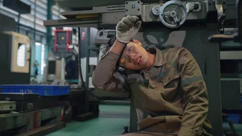 Worker rests, exhausted, in factory setting Vidéo 346269014