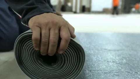 Worker rolling big carpet from the ground Video stock 128929475