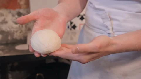 Worker rolls dough piece making ball form in restaurant Stock Footage 132126111