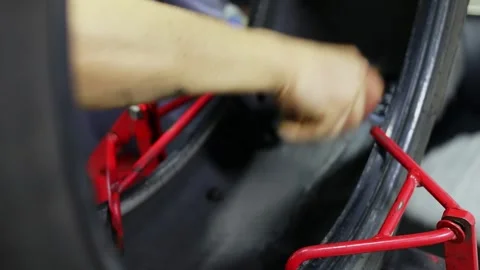Worker rolls patch on internal surface of tyre during car wheel repair. Slow 스톡 동영상 276366519