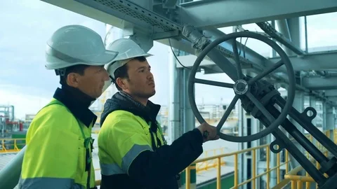 Worker rotating wheel at large oil refinery Stock Footage 76683059
