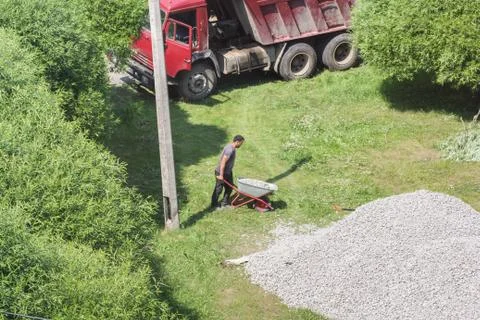 Worker with a rubble wheelbarrow. 库存照片