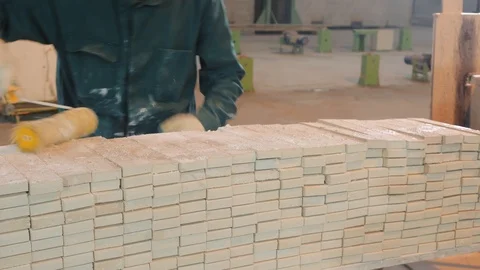 Worker runs yellow roller along white concrete bricks stack Stock Footage 124893009
