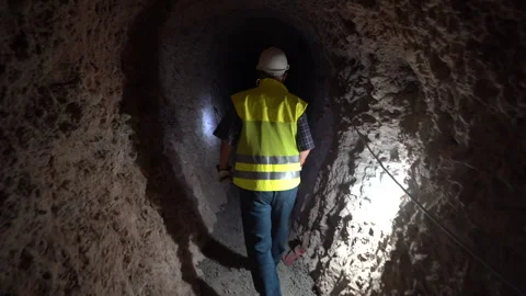 Worker in Safety Gear Walking Through Dark Underground Mine Shaft Vídeos de archivo 334939770