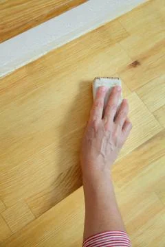 Worker sanding plank at stairs using sand paper Фото