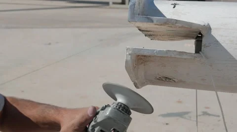 Worker sanding yachts mast with angle grinder. Close up Stock Footage 57736983