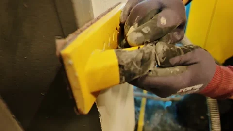 Worker Sands Surface With Vacuum-Connected Tool for Dust Controlled Renovation Stock Footage 342781065