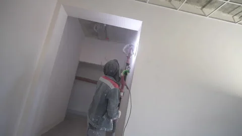 Worker sands wall removing plaster flaws with care Stock-Footage 310601856